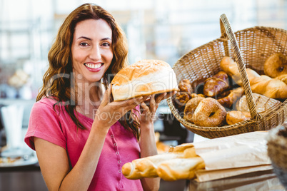 Pretty brunette showing loaf of bread