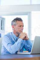 Concentrated businessman looking at laptop computer