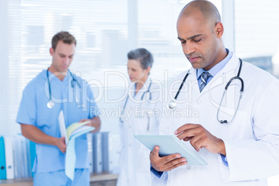 Attentive doctor using his tablet