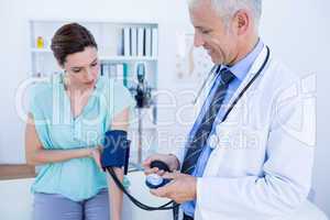Doctor checking blood pressure of a young woman