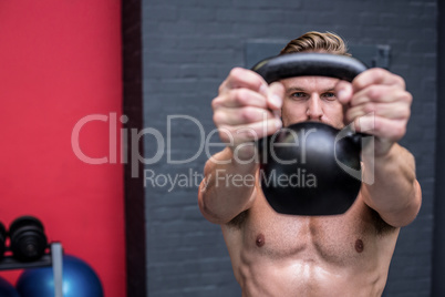 Muscular man lifting a kettlebell