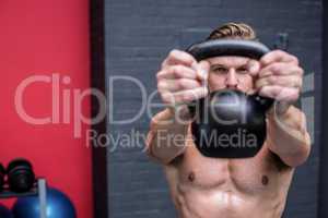 Muscular man lifting a kettlebell