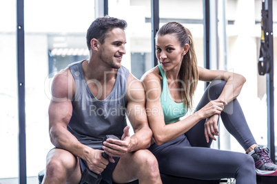 Muscular couple sitting on the bench