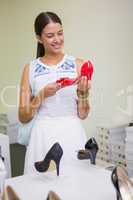 Young smiling woman looking at a shoe