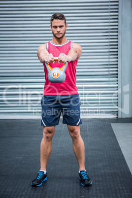 Portrait of muscular man lifting a kettlebell