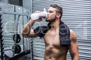 Muscular man drinking protein cocktail