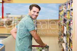 Portrait of smiling man pushing his trolley in aisle