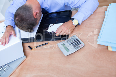 Exhausted businessman sleeping on the desk