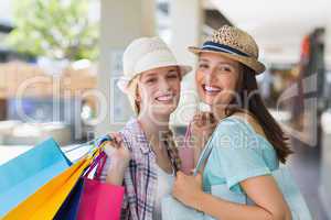 Happy women smiling at camera with shopping bags