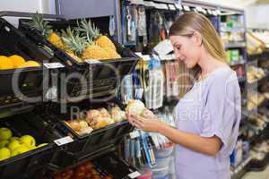 Smiling pretty blonde woman buying onions