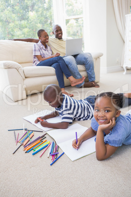 Happy siblings on the floor drawing