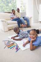 Happy siblings on the floor drawing