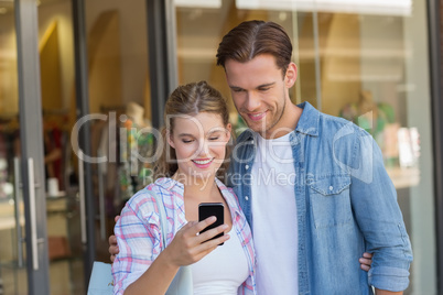 Happy couple looking at smartphone