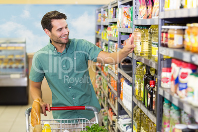 Smiling man taking a oil in the aisle