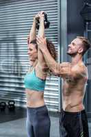 Muscular trainer show how to lift kettlebells