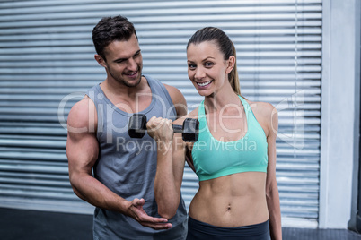 A muscular woman lifting dumbbells