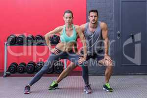 Muscular couple doing leg stretchings