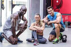 Three muscular athletes smiling at the camera