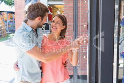 Young happy couple looking at a window