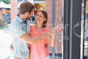 Young happy couple looking at a window