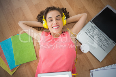 Young creative businesswoman enjoying music