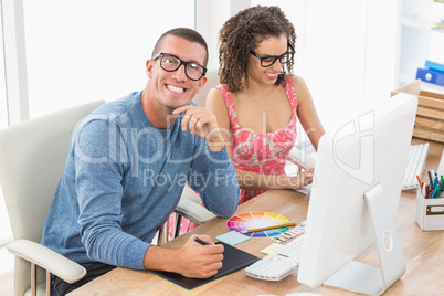 Happy coworkers working together with computer