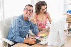 Happy coworkers working together with computer