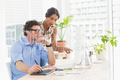 Casual businesswoman looking at colleagues computer