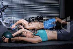 Muscular couple doing abdominal crunch