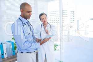 Concentrated medical colleagues working with tablet computer