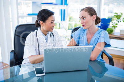 Doctor and nurse looking at laptop