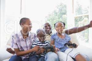 Happy smiling family playing video games together