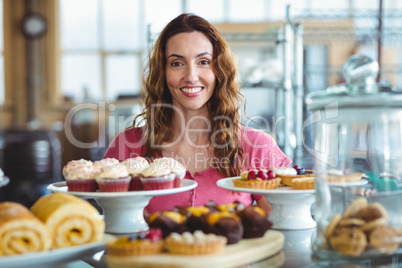 Pretty brunette smiling at camera behind counter
