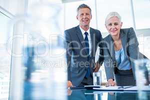 Business people looking at camera behind desk