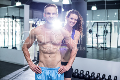 Smiling muscular couple looking at the camera