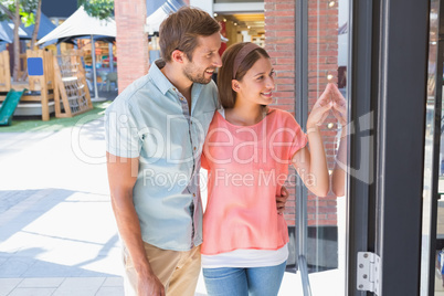 Young happy couple looking at a window