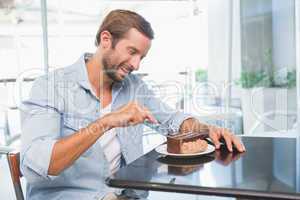 Young happy man eating his cake