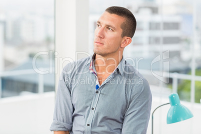 Thoughtful businessman looking away in the office