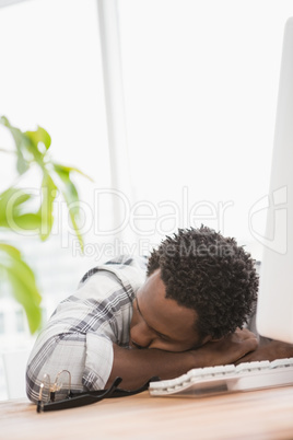 Tired casual businessman sleeping on desk