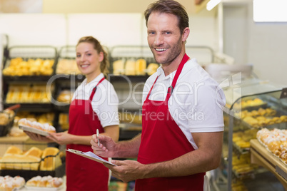 Portrait of a two smiling bakers looking at camera