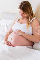 Pregnant woman looking at her belly