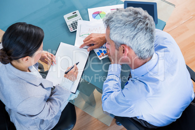 Business people looking at documents with graphics