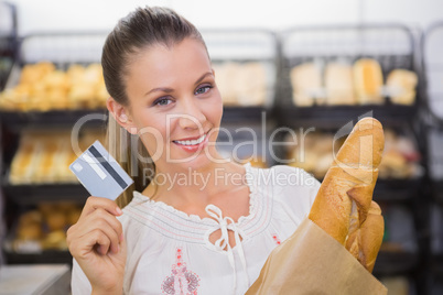 A pretty blonde woman buying bread