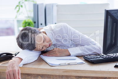 Tired businesswoman sleeping at her desk