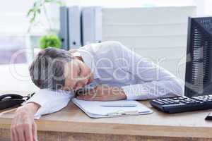 Tired businesswoman sleeping at her desk