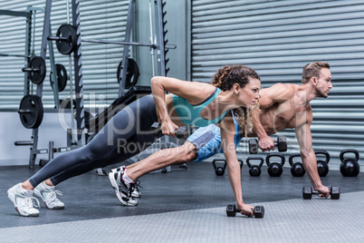 Muscular couple doing plank exercise together