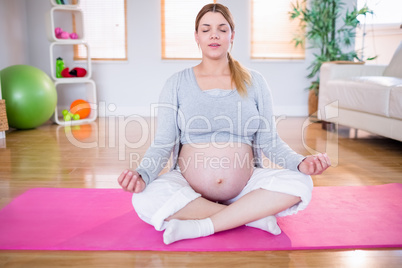 Pregnant woman doing yoga on exercise mat