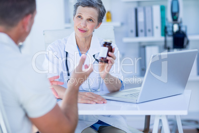 Female doctor giving a box of pills to her patient
