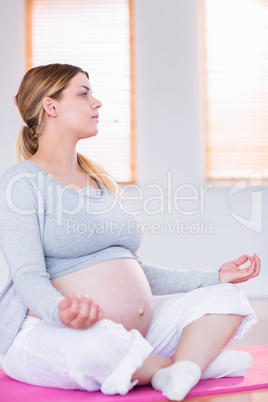 Pregnant woman doing yoga on exercise mat