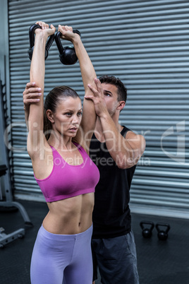 Muscular trainer show how to lift kettlebells